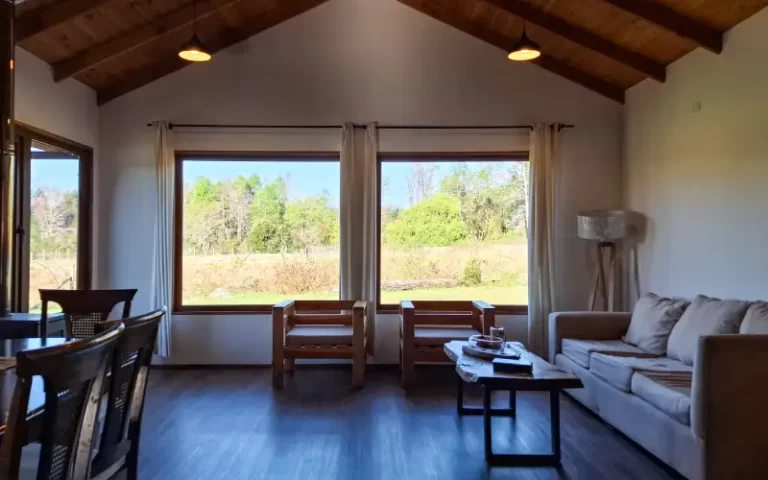 Living comedor con ventanales y vista al jardín en Casa Altos de Molco