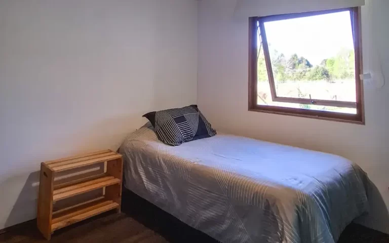 Dormitorio simple con ventana abierta hacia el paisaje en Casa Altos de Molco